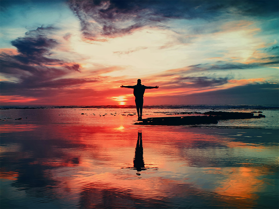 Person am Strand bei Sonnenuntergang