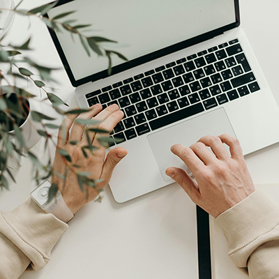 Hände die am Laptop arbeiten