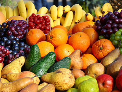 Orangen Bananen Trauben Birnen Äpfel Ananas Avocado auf einem Haufen